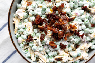 Homemade Creamy Bacon Pea Salad in a Bowl, overhead view. Flat lay, from above, top view. Close-up.