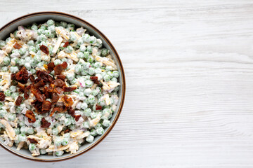 Homemade Creamy Bacon Pea Salad in a Bowl, top view. Flat lay, from above, overhead view. Copy space.