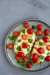 Homemade Caprese Chicken Parmesan with tomato, mozzarella and basil on a Plate, top view. Copy space.