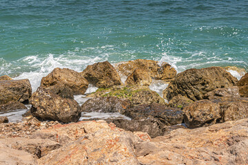 seascape background of sea surf on a rocky shore in clear weather