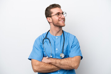 Young surgeon doctor caucasian man isolated on white background happy and smiling