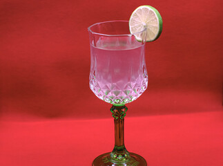glass of lemon juice on a red background