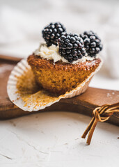 muffin cupcake paper mold carrot cake topped with whipped cream and berries 
blackberry
