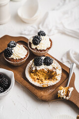 muffin cupcake paper mold carrot cake topped with whipped cream and berries 
blackberry