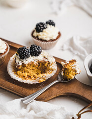 muffin cupcake paper mold carrot cake topped with whipped cream and berries 
blackberry