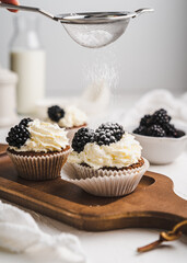muffin cupcake paper mold carrot cake topped with whipped cream and berries 
blackberry