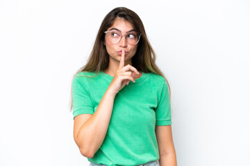 Young caucasian woman isolated on white background showing a sign of silence gesture putting finger in mouth
