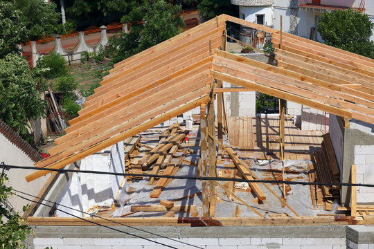 Roof building at new house construction. Brown roof tiles covering estate