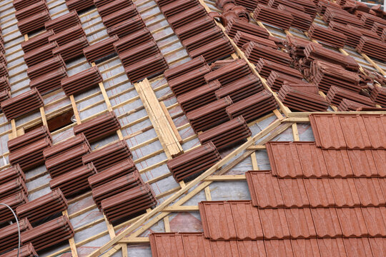 Roof building at new house construction. Brown roof tiles covering estate