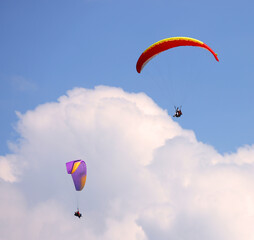 Paragliders flying over mountains in Interlaken, Switzerland. Silhouette of Swiss Alps. Tandem paragliding. Dawning, sunset. Extreme sports. Adventure lifestyle. Adrenaline, risk concept