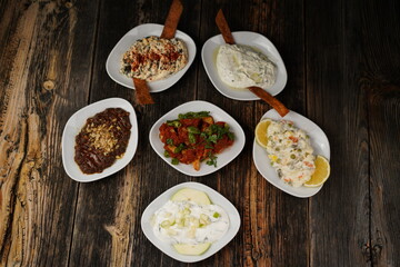 Traditional Turkish and Greek food appetizer (meze) on wood background. Turkish cuisine cold appetizers like  Russian salad, spicy Turkish appetizer ezme, Carrot tarator etc. Selectively focused.