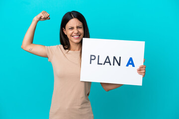 Young woman over isolated background holding a placard with the message PLAN A doing strong gesture