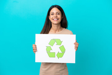 Young woman over isolated background holding a placard with recycle icon with happy expression