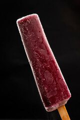 Popsicles on a stick isolated on a black background. Fruit ice