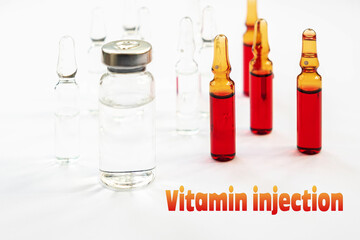 Inscription vitamin injection. Ampoules with red and transparent liquid on a white background.