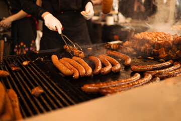 Blurry background of bbq street food for sale. Fried baked sausages, hot dog on street food outdoor market stall in Krakow Poland 