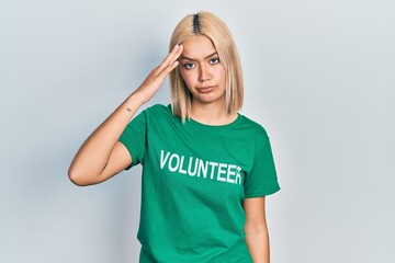 Beautiful blonde woman wearing volunteer t shirt worried and stressed about a problem with hand on...