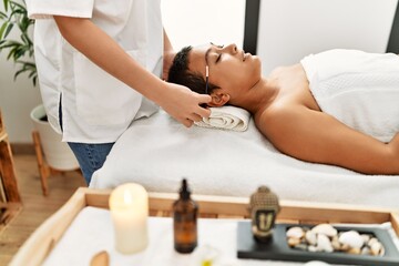 Young hispanic woman having eyebrows treatment at beauty center