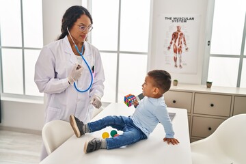 Obraz premium Mother and son pediatrician and patient auscultating chest at clinic