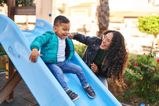 Mother and son playing on slide at park