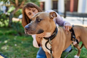 Young caucasian girl smiling happy standing with dog at the park.