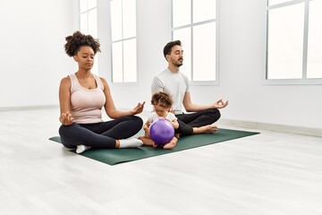 Couple and daughter training yoga at sport center