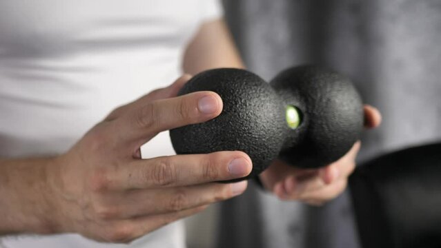 Back massager in male hands. for the prevention and relaxation of spasmodic muscles when working at a computer.