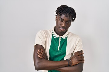 African man with dreadlocks standing over isolated background skeptic and nervous, disapproving expression on face with crossed arms. negative person.