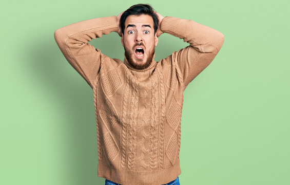 Young hispanic man wearing casual clothes crazy and scared with hands on head, afraid and surprised of shock with open mouth