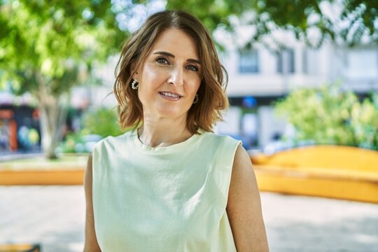 Middle age woman smiling happy standing at the city.