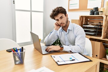 Young hispanic businessman relaxed working at the office.