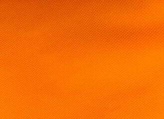 coarse porous orange color non-woven fabric surface background. polypropylene fabric texture