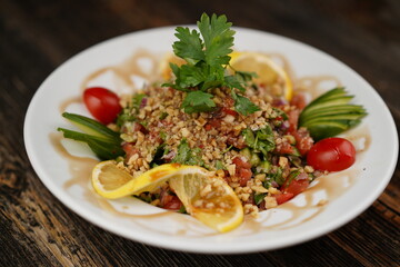 Finely chopped Turkish salad on a wood background. Salad with lemon and parsley. Salad made with fresh vegetables. 