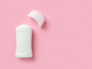 Solid antiperspirant over pink background with copy space. Open white plastic tube of body deodorant close-up. Toiletries for reduce perspiration, hygiene and body care concepts.