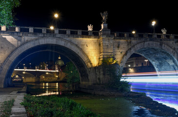 Fototapeta na wymiar A night long exposure along the Tiber river in Rome Italy during the busy summer travel season.