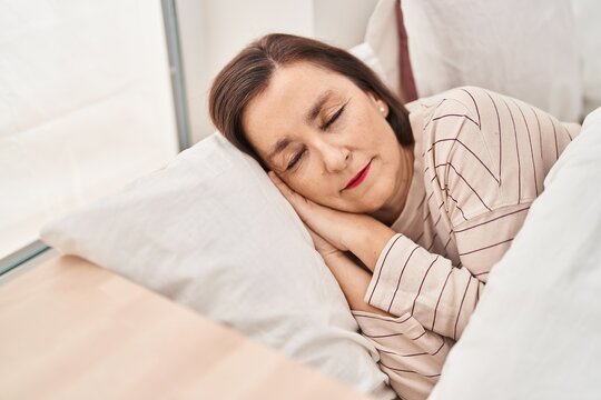 Middle age woman lying on bed sleeping at bedroom