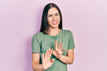 Beautiful woman with blue eyes wearing casual t shirt disgusted expression, displeased and fearful...