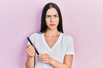 Beautiful woman with blue eyes using file nail skeptic and nervous, frowning upset because of...