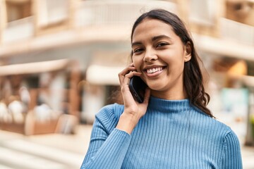 Young african american woman smiling confident talking on the smartphone at street