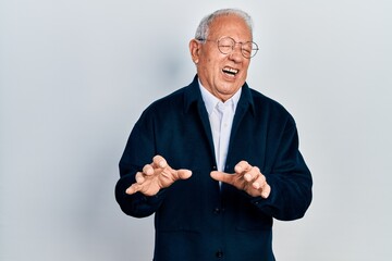 Senior man with grey hair wearing casual style and glasses disgusted expression, displeased and fearful doing disgust face because aversion reaction. with hands raised