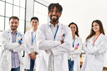 Group of young doctor smiling happy standing with arms crossed gesture at the clinic office.