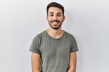 Young hispanic man with beard wearing casual t shirt over white background with a happy and cool smile on face. lucky person.