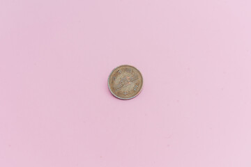 Moneda china de 10 yuanes, sobre un fondo rosa.