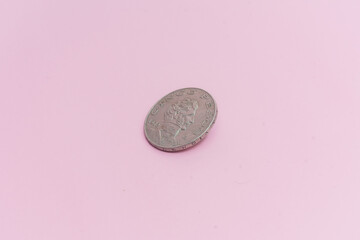 Una antigua moneda mexicana de 5 pesos, de plata de 1972, sobre fondo rosa.