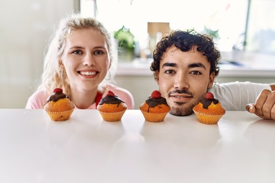 Young couple smiling happy cooking pumpkins at kitchen.