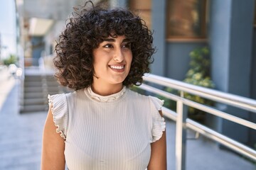 Young middle east woman smiling happy standing at the city.