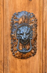 Antiker Türklopfer mit Löwenkopf an einer massiven Holztür