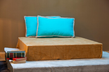 Bedroom reading nook with wing chair, bamboo floor lamp, blue books and cushions and upholstered...
