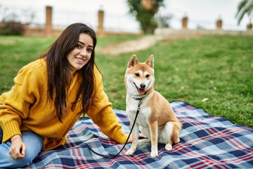 Beautiful young woman with shiba inu dog at park