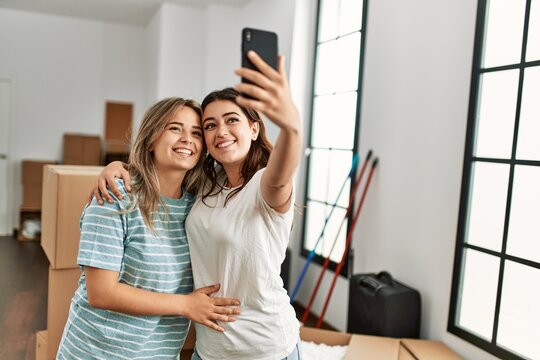 Young couple smiling happy make selfie by the smartphone at new home.